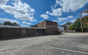 A parking lot with a building labeled 'Heart of Wilson' and a clear blue sky with clouds.