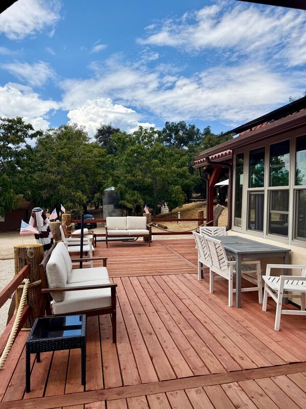 A wooden deck with outdoor furniture, including a sofa, chairs, and a table.