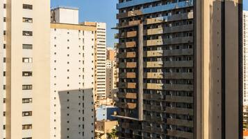 Un edificio de gran altura con varios pisos, ventanas amplias y un diseño arquitectónico moderno.