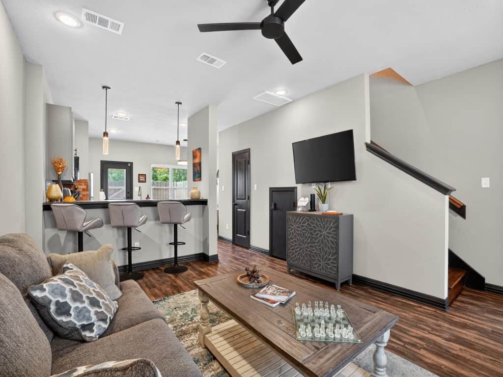 A modern living room with a sofa, coffee table, and a TV mounted on the wall.