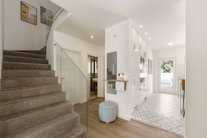 Ein modernes Interieur mit Treppe, Küchenbereich und Essplatz.