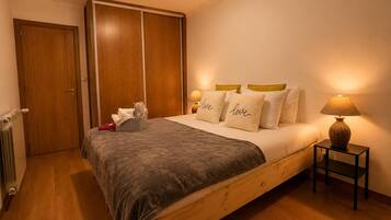 Une chambre à coucher avec un lit en bois, une table de chevet avec une lampe, une armoire et un radiateur.