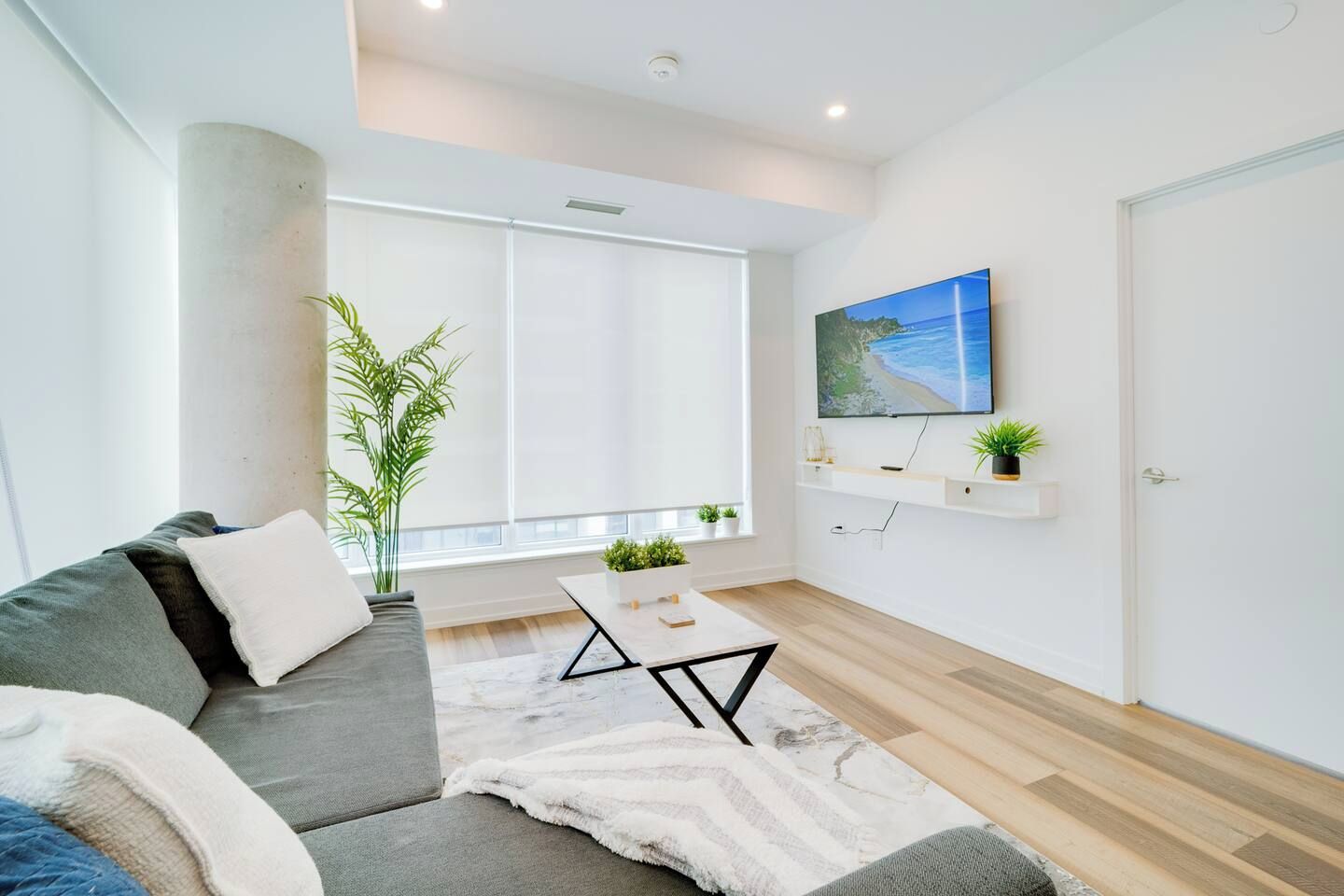 A modern living room with a sofa, coffee table, and a large window.