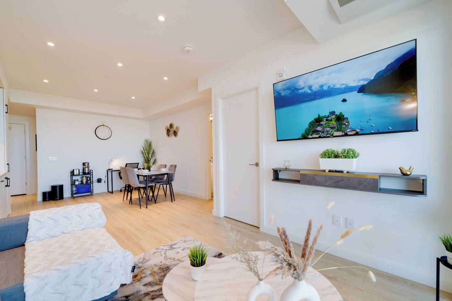 Un salon moderne doté d’un téléviseur à écran plat, d’un coin repas et d’un espace salon confortable.