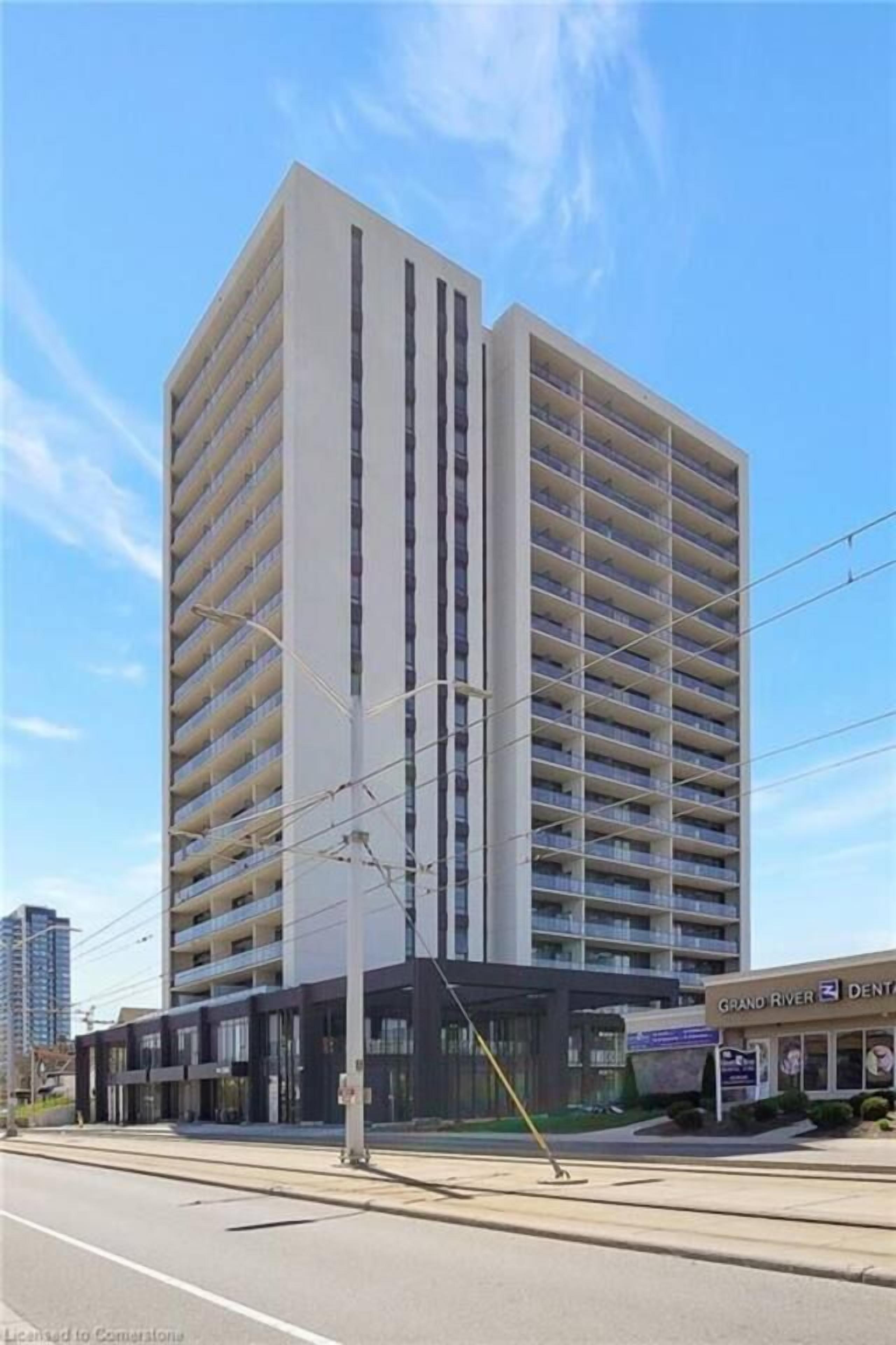 A multi-story building with a modern architectural design, featuring a flat facade and a series of balconies.