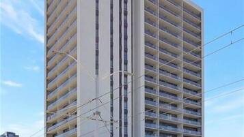 A multi-story building with a modern architectural design, featuring a flat facade and a series of balconies.