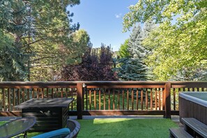 A deck with a grill, a table, and a bench. - Topaz Ketchum Retreat - pet friendly home (Ketchum)