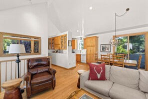 A spacious living area with a leather armchair, a sofa, and a dining table set for four. - Topaz Ketchum Retreat - pet friendly home (Ketchum)