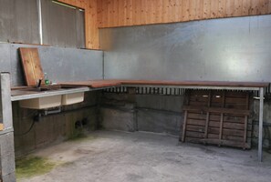 A kitchen with a wooden countertop, a sink, and a metal backsplash. - L'IDOLIVIER, location de vacances (La Plaine-des-Palmistes)