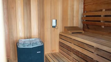 Una sauna con bancos de madera y una unidad de ventilación.