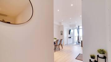 A modern interior with a dining area, a flat-screen TV, and a large mirror.