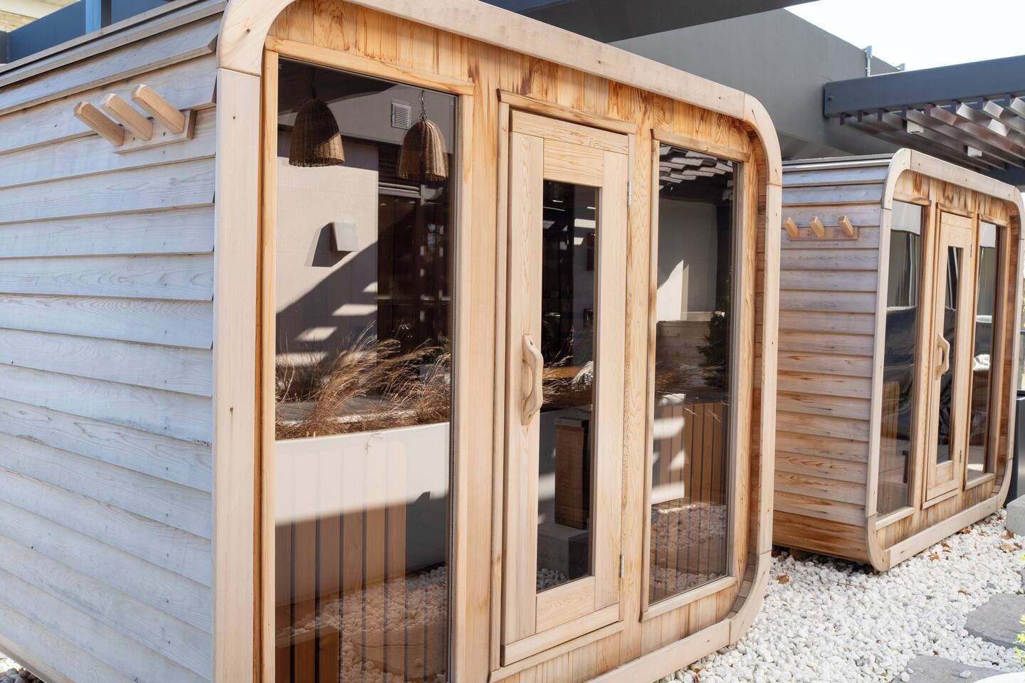 A wooden structure with large windows and a door, possibly a sauna or a similar facility.