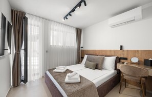 Une chambre d’hôtel équipée d’un lit, d’un bureau, d’une chaise et d’un appareil de climatisation.