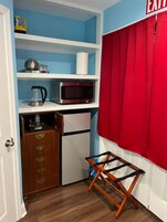 Cocina compacta con microondas, hervidor y cajones para guardar objetos.