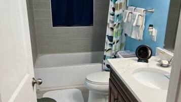 Une salle de bain avec une baignoire, des toilettes et un lavabo.