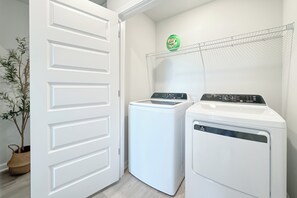 A laundry room with two front-loading washing machines and a drying rack. - 3-bedroom townhome in perfect Orange Beach with AC (Orange Beach)