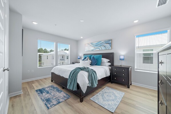 A bedroom with a bed, nightstands, a dresser, and two windows with blinds. - 3-bedroom townhome in perfect Orange Beach with AC (Orange Beach)