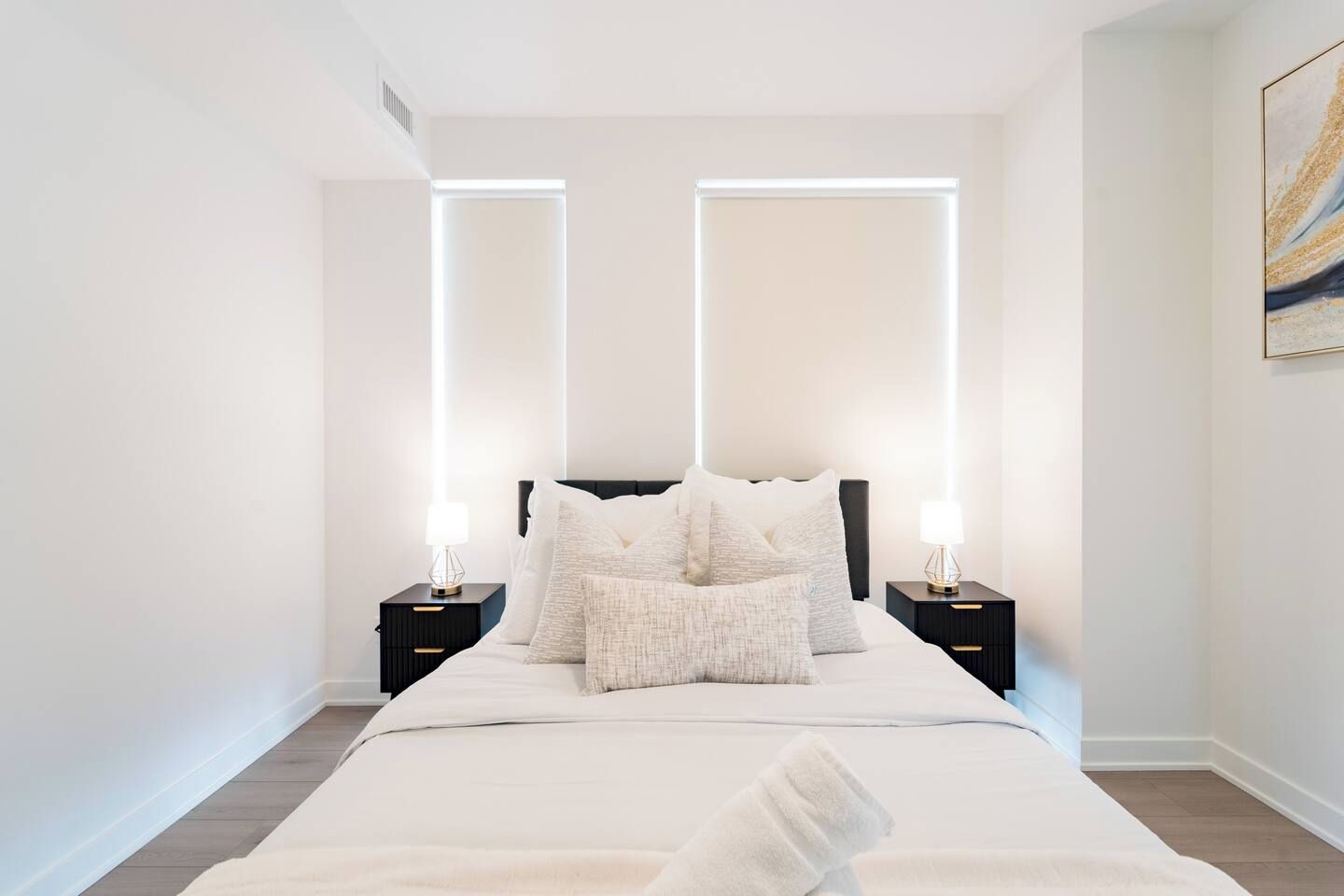 A bedroom with a bed, two bedside tables, and a nightstand.