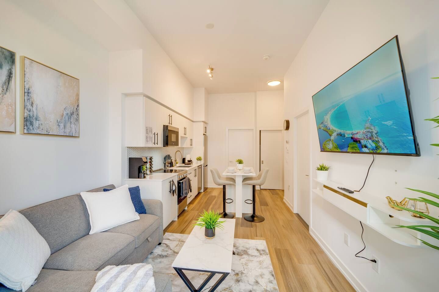 A modern living room with a sofa, coffee table, and a dining area with a table and chairs.