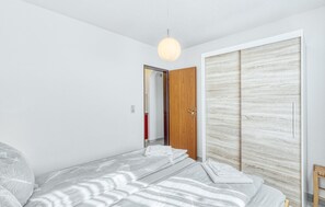 A bedroom with a bed, a wardrobe, and a hanging light fixture. - Nice apartment in Thalfang with WiFi (Thalfang)