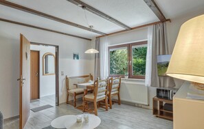 A dining area with a table, chairs, and a window with a view of greenery. - Nice apartment in Thalfang with WiFi (Thalfang)