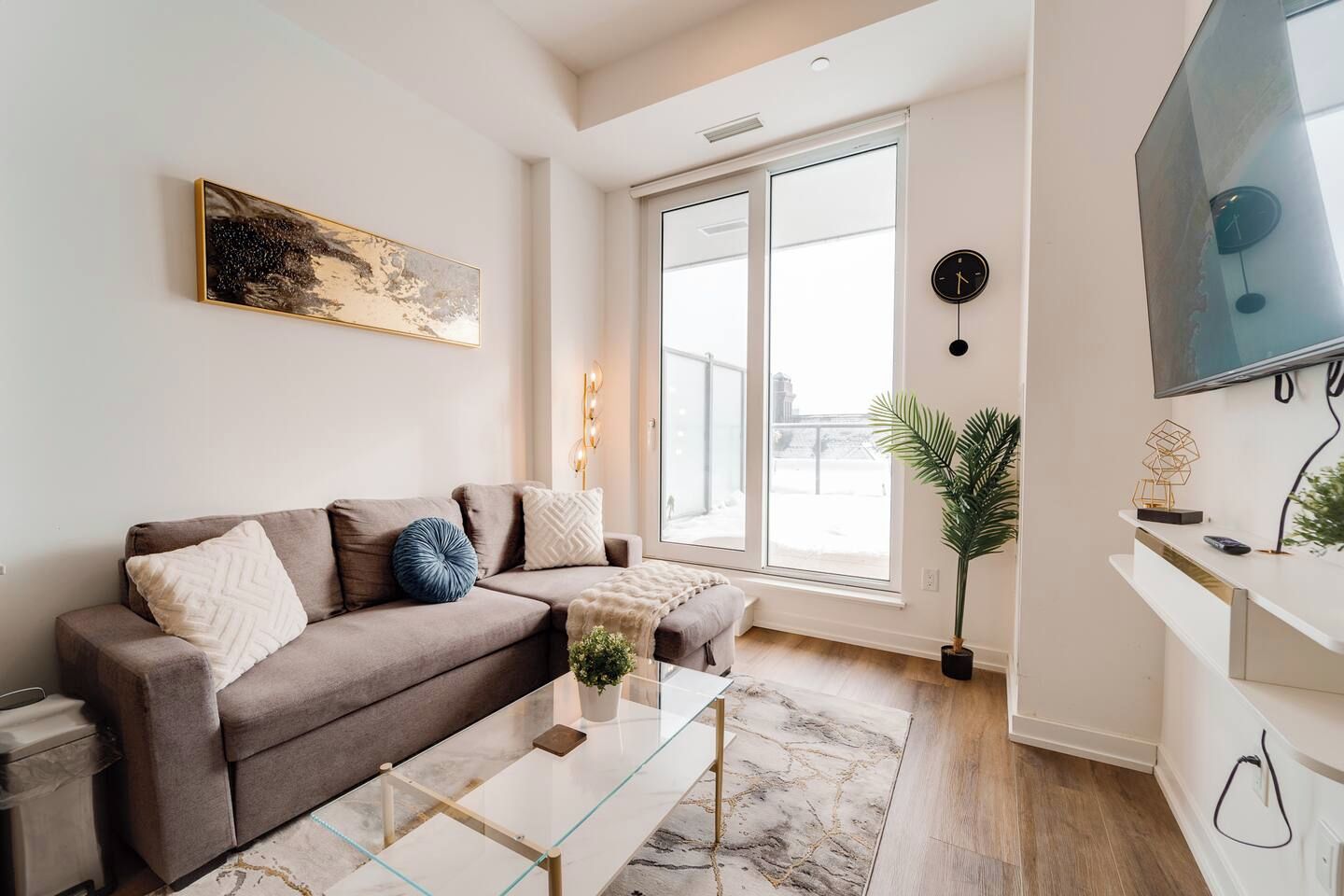 A modern living room with a sofa, coffee table, and a TV.