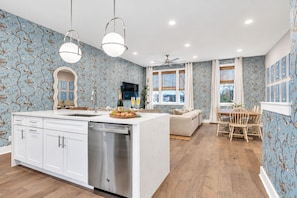A modern kitchen with a central island, white cabinetry, and a dishwasher. - Fall in Nashville: sleeps 12, 2-car garage & fire pit, near Broadway & Geodis (Nashville)