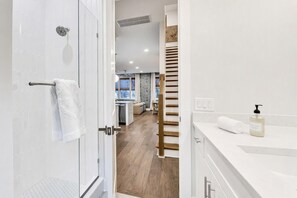Een moderne badkamer met een douche, toilet en wastafel.