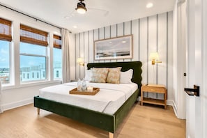 A bedroom with a green headboard and striped wallpaper offers a quiet retreat, with touches of personality that match the rest of the house - rooftop deck, fire pit & skyline views near Geodis Park | sleeps 12 (Nashville)