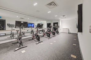 A gym with stationary bikes, mirrors, and exercise equipment. - Modern Condo in Central KW w/ Gym (Kitchener)
