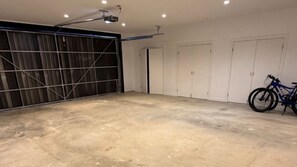 Garatge amb sòl de formigó, una bicicleta i una porta de garatge tancada.