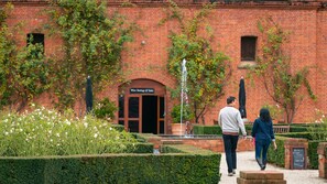 A brick building with a sign for wine tastings and sales. There is a fountain and well-maintained hedges in the foreground. - 6 bedrooms sleeping up to 20 guests in Bundalong. (Bundalong)