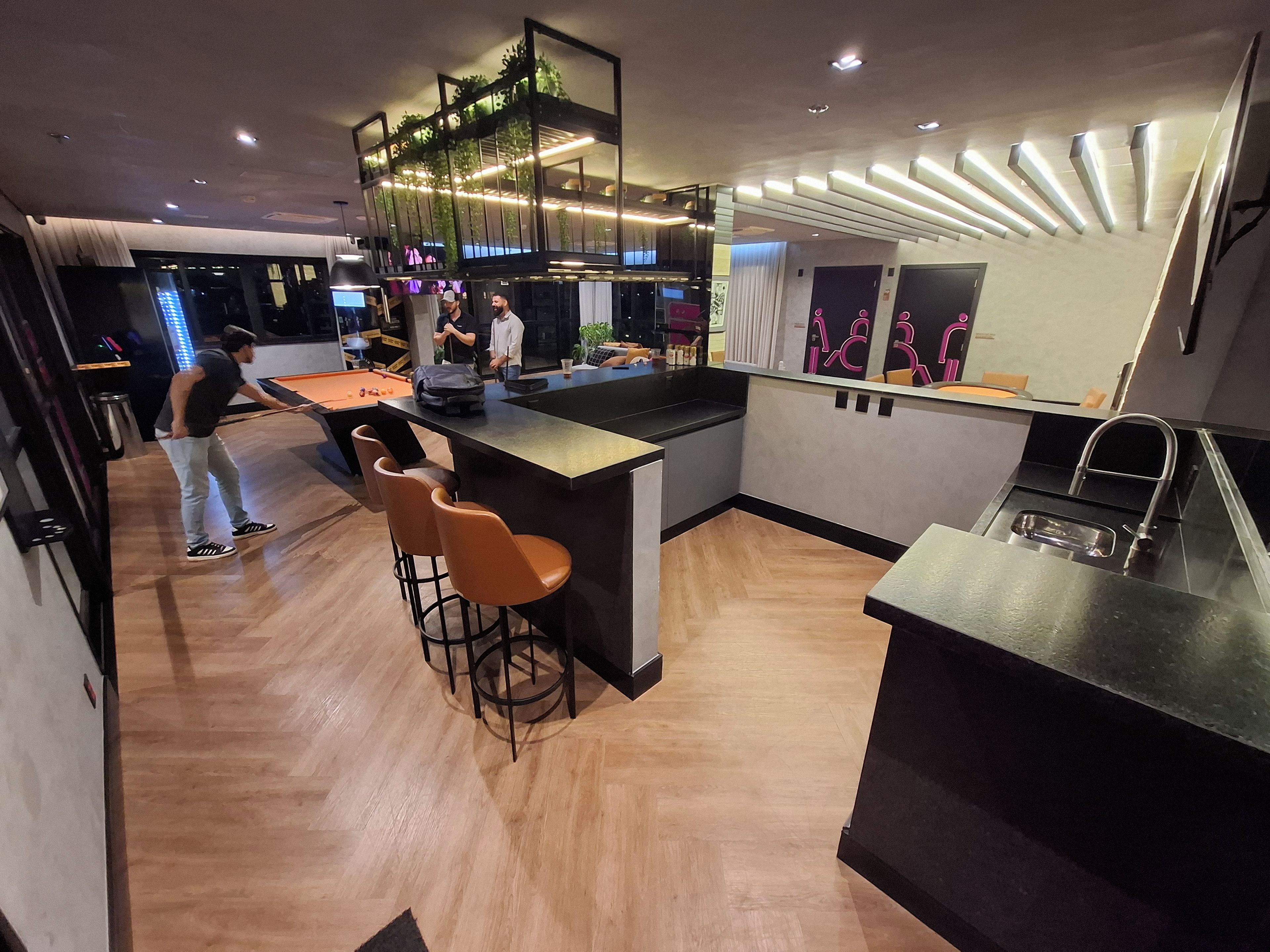 Una cocina moderna con una isla central, taburetes de bar y una zona de bar.