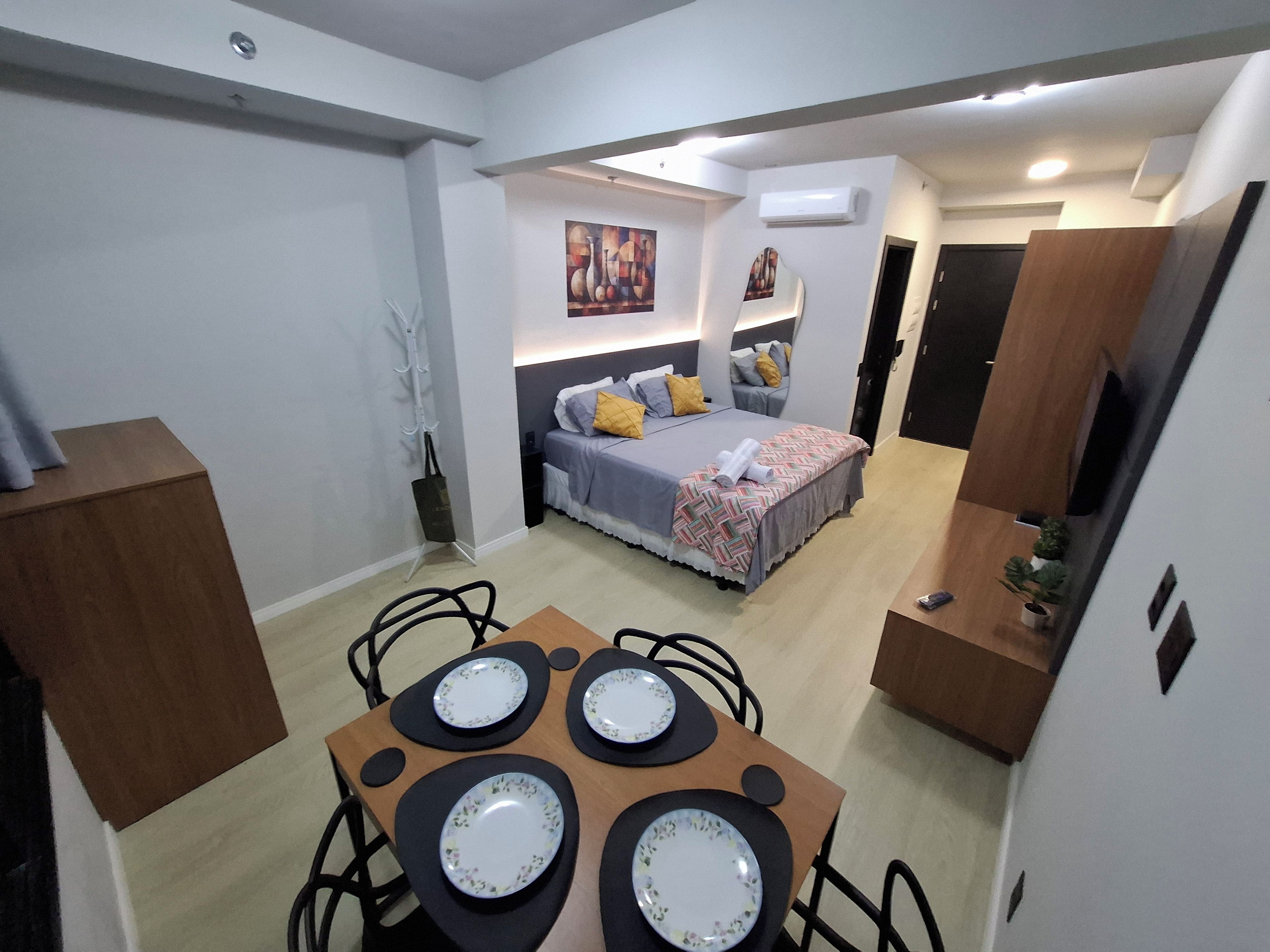 A modern bedroom with a bed, bedside tables, and a painting on the wall.