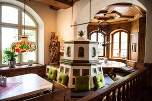 Een eetgedeelte met een ronde tafel, banken en een decoratieve torenconstructie.