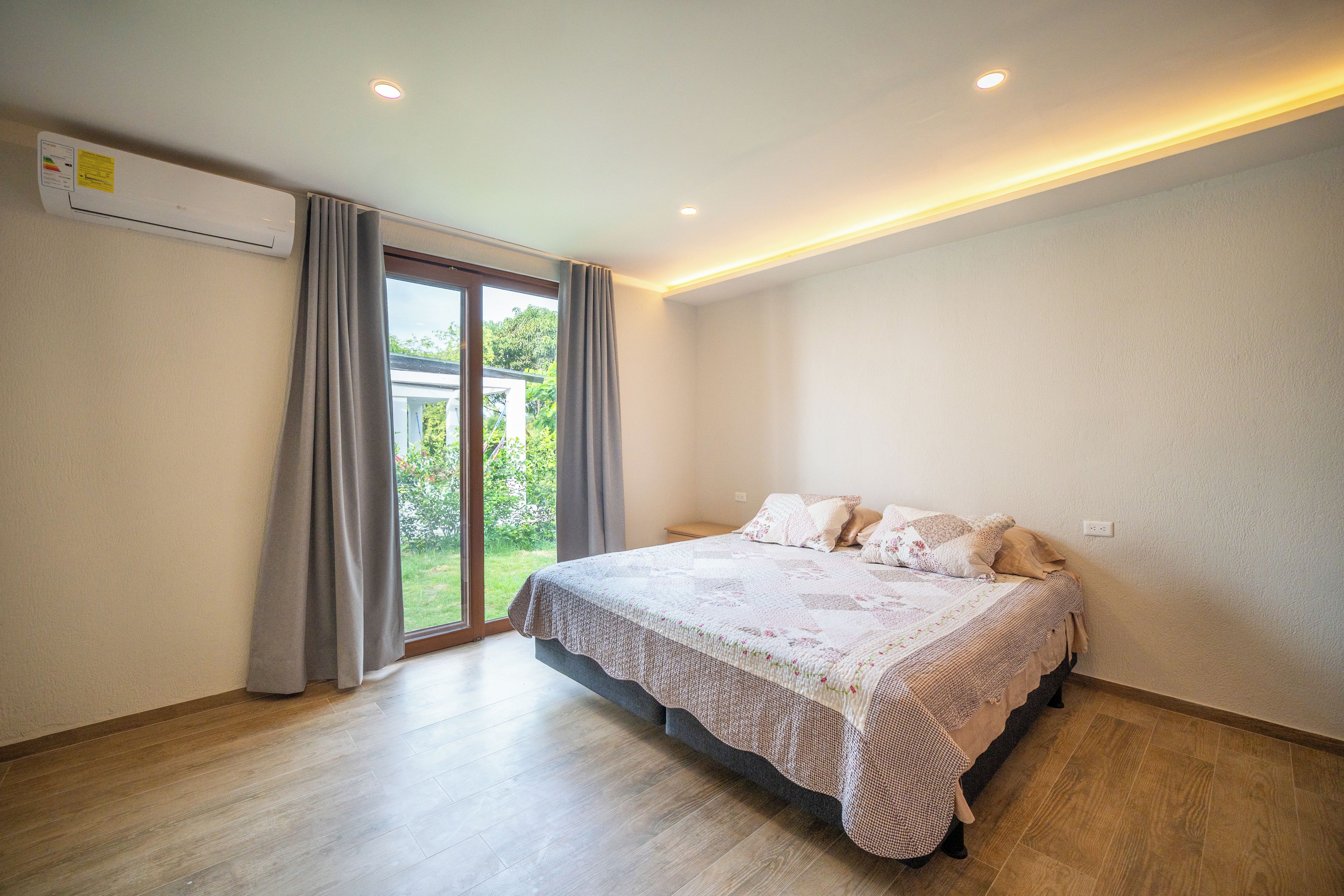 A bedroom with a bed, a window, and a door.