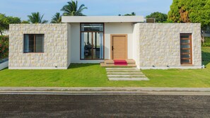 A modern house with a stone facade, a wooden door, and a glass entrance.
