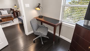 A modern office space with a desk, chair, and a window with blinds.