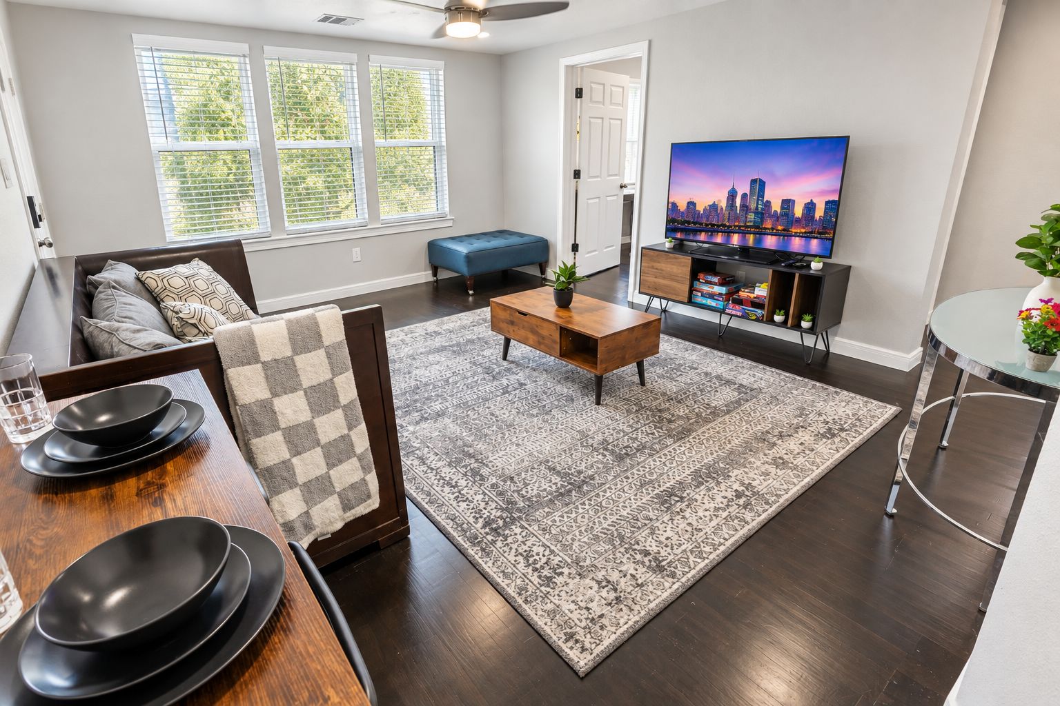 A modern living room with a sofa, coffee table, and a flat-screen TV.
