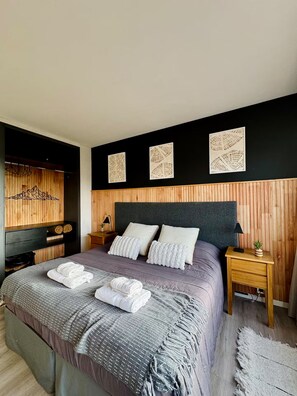 A modern bedroom with a bed, two nightstands, a TV, and decorative wall art. - Vista al lago a pasos del Centro Cívico (San Carlos de Bariloche)