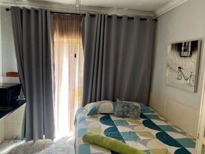 Une chambre à coucher avec un lit, un bureau et un tableau accroché au mur.