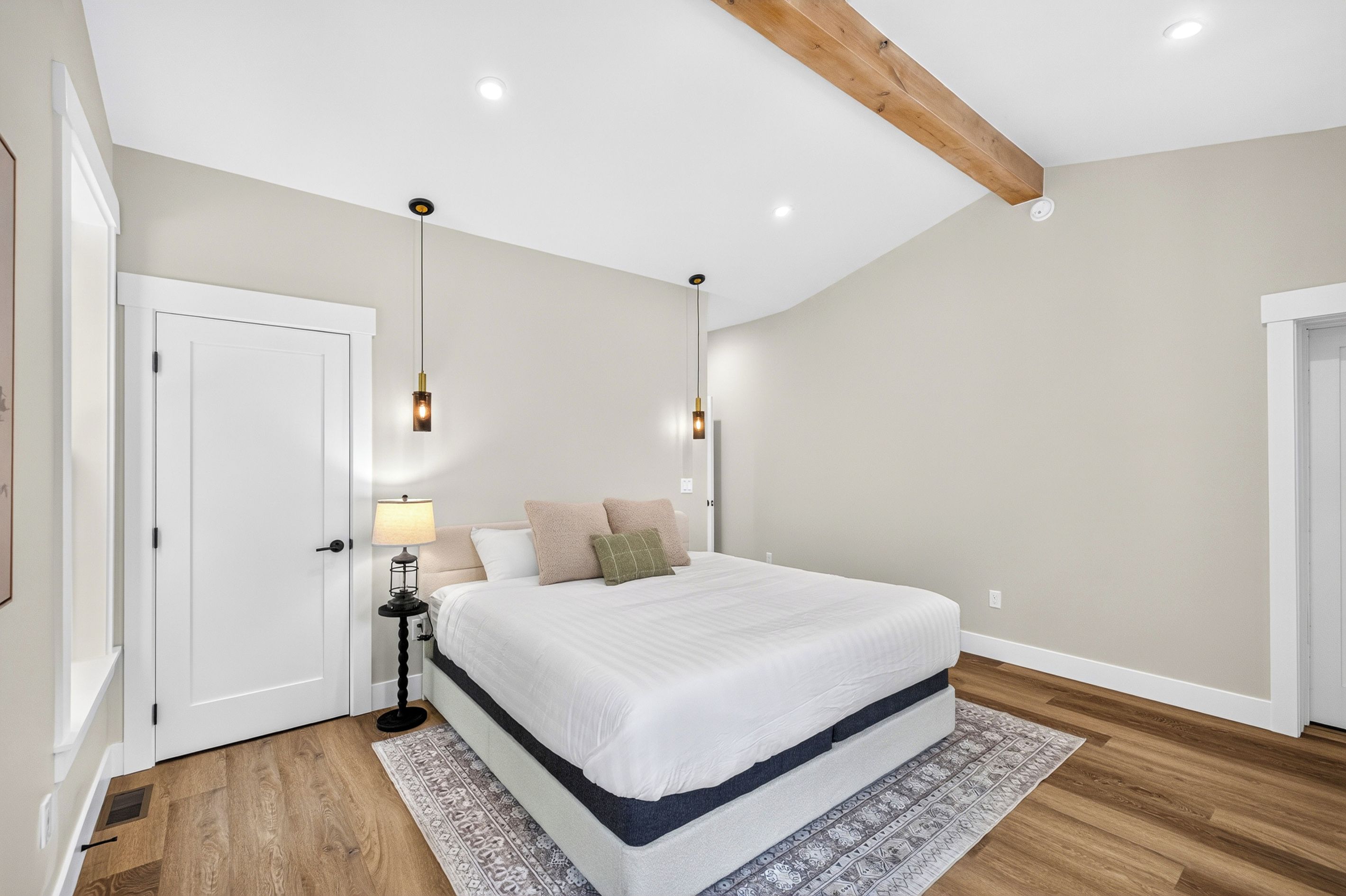 Une chambre à coucher avec un lit, des lampes de chevet, une table de nuit et un tapis à motifs.