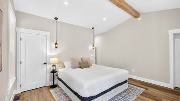 Une chambre à coucher avec un lit, des lampes de chevet, une table de nuit et un tapis à motifs.