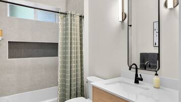 This elegant full bathroom with bathtub separates the two downstairs bedrooms.