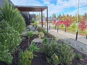 An outdoor seating area with a covered patio, surrounded by landscaped gardens and trees with autumn foliage. - Hotel Boutique 501 (Los Angeles)