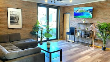 Una sala de estar moderna con un sofá, una mesa de centro y un televisor montado en la pared.