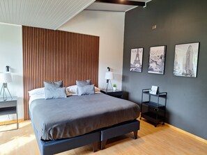 A modern bedroom with a large bed, a wooden slat headboard, and three framed pictures on the wall. - Hotel Boutique 501 (Los Angeles)