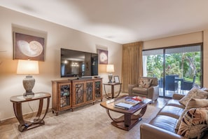 A living room with a sofa, coffee table, TV, and a cabinet. - 160 Steps from kitchen sink to sand! Platinum Interior. 1431sf - New Ownership! (Lahaina)
