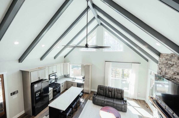 A modern loft-style living space with a kitchen, dining area, and seating area.