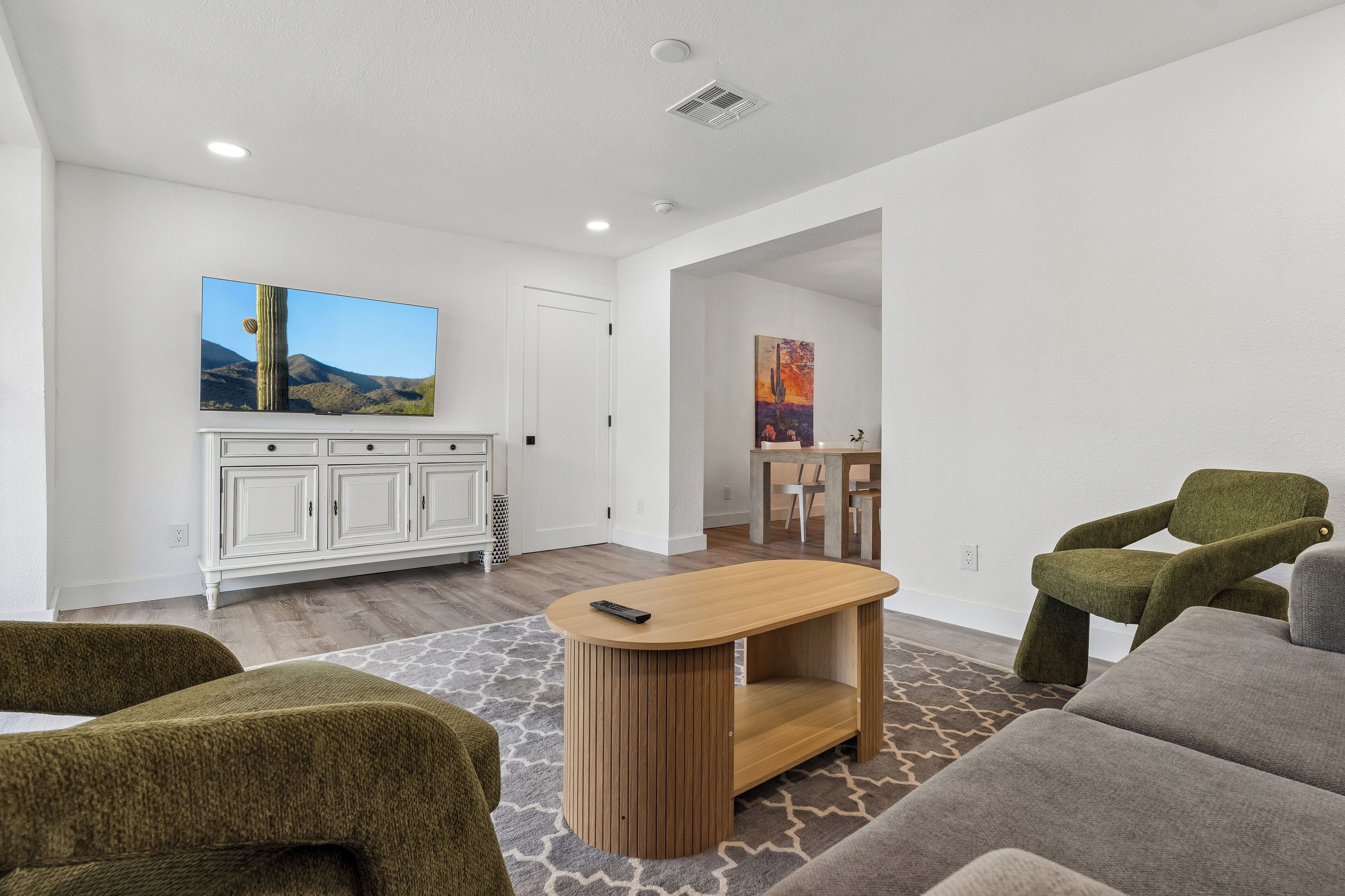 A modern living room with a flat-screen TV, a wooden coffee table, and a sofa.